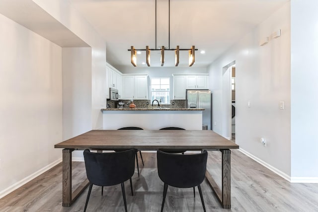 dining room with sink and light wood-type flooring