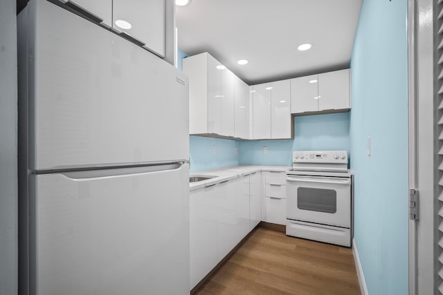 kitchen featuring white cabinetry, white appliances, and wood-type flooring