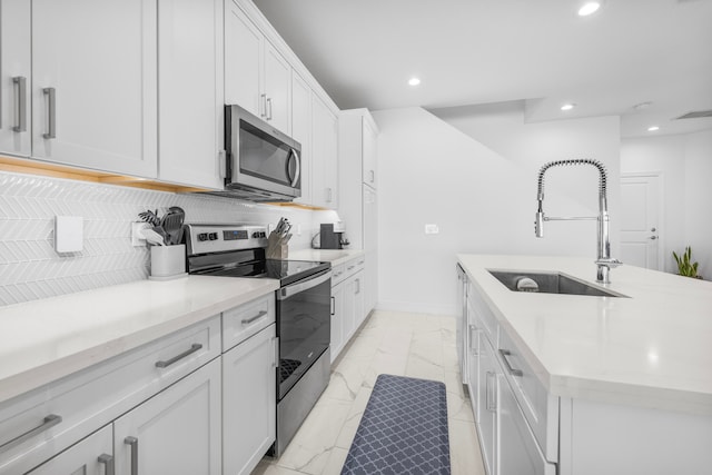 kitchen featuring white cabinetry, tasteful backsplash, light tile patterned floors, sink, and appliances with stainless steel finishes