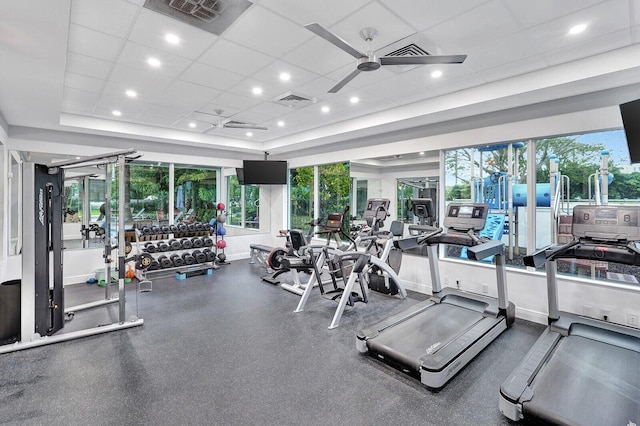 gym featuring a healthy amount of sunlight and a drop ceiling