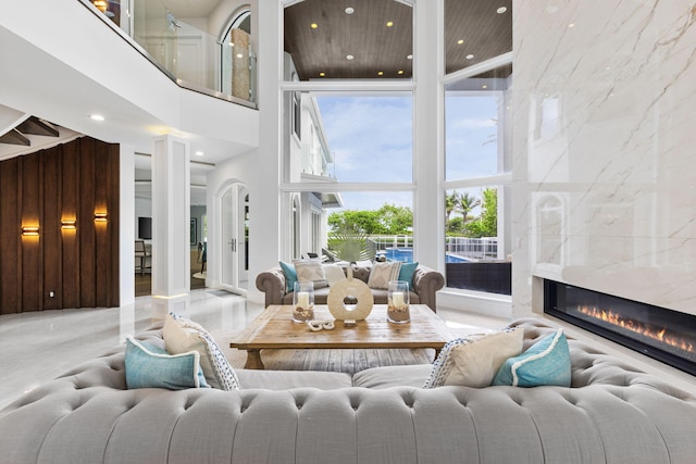 living room with a high ceiling, a fireplace, decorative columns, and recessed lighting