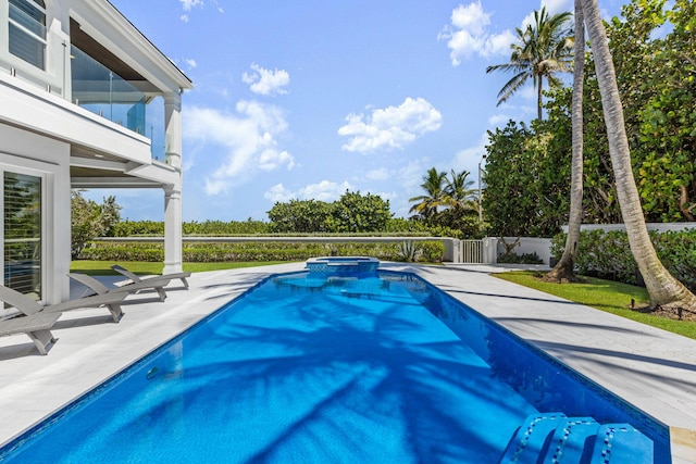 view of swimming pool with a patio area, fence, and a pool with connected hot tub