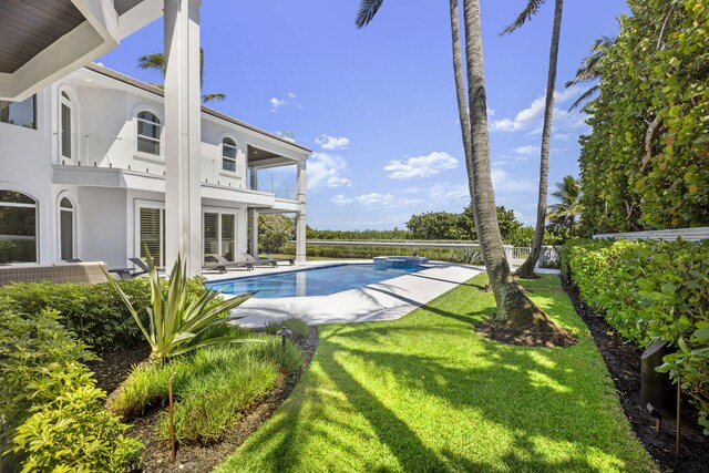 outdoor pool with a patio and a yard