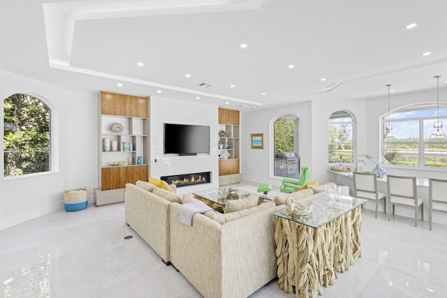 tiled living room with built in shelves and a raised ceiling