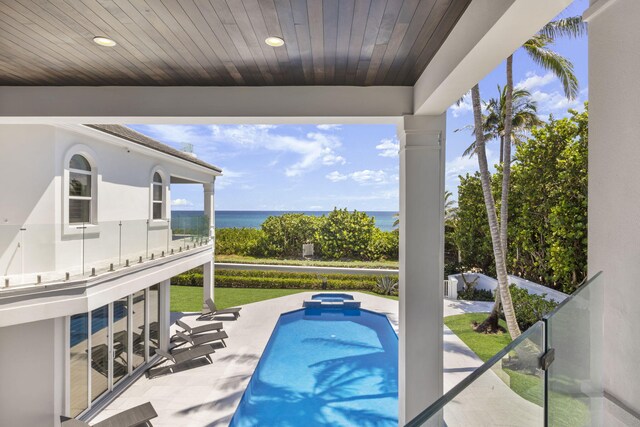 view of pool with a water view and a patio