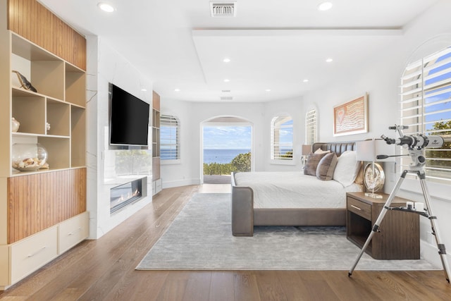 bedroom featuring hardwood / wood-style floors, a fireplace, visible vents, and recessed lighting