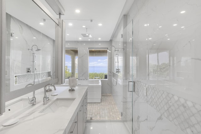 bathroom with a freestanding tub, a marble finish shower, vanity, and recessed lighting