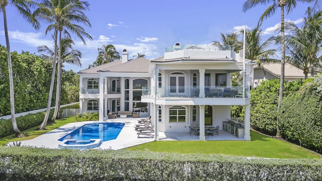 rear view of house with a yard, a patio area, and a balcony