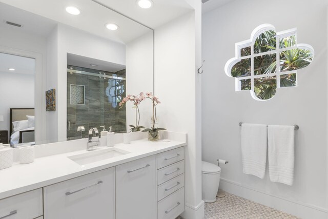 bathroom featuring tile patterned flooring, toilet, walk in shower, and vanity