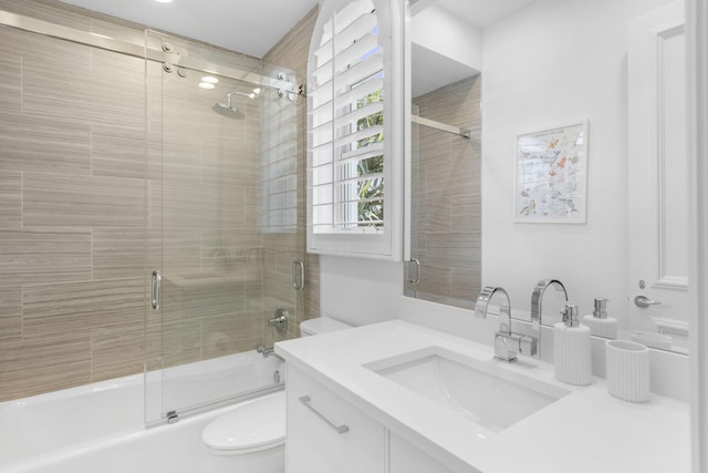 full bathroom featuring toilet, enclosed tub / shower combo, and vanity