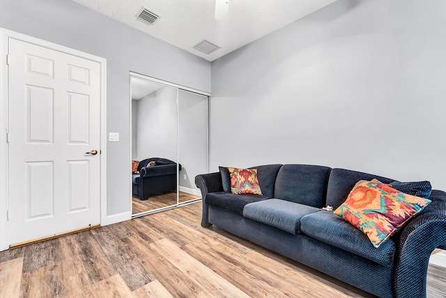 living room featuring a textured ceiling and hardwood / wood-style floors