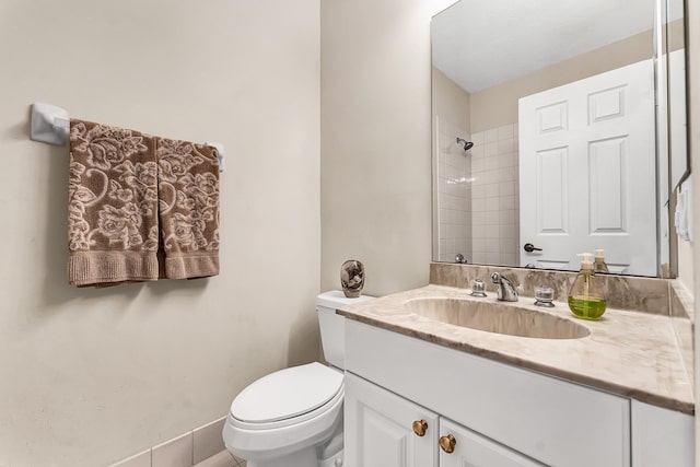 bathroom with vanity, toilet, and a tile shower