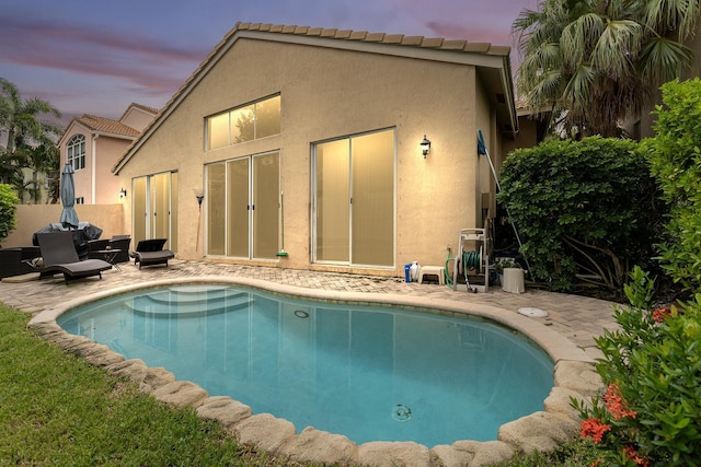 pool at dusk with a patio