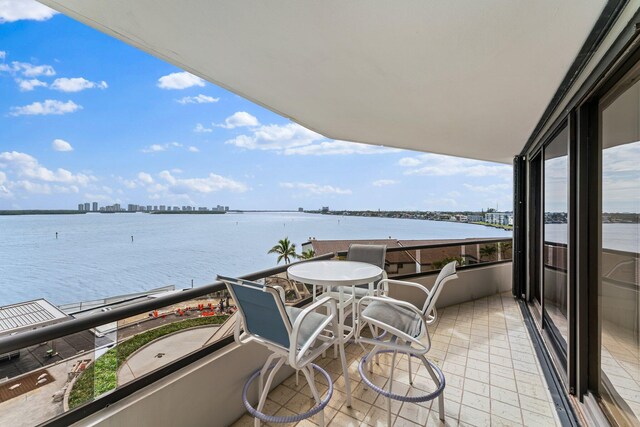 dining room featuring ornamental molding, expansive windows, a chandelier, and a water view