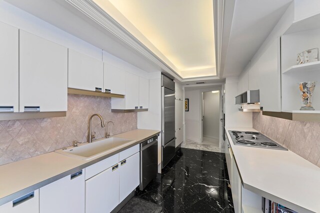 kitchen with appliances with stainless steel finishes, a tray ceiling, and white cabinets