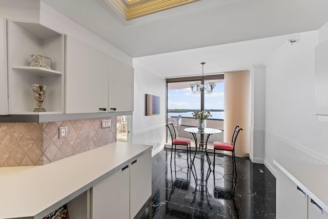 100 Lakeshore Dr Unit 457, North Palm Beach, FL 33408 - kitchen with granite floors, ornamental molding, decorative backsplash, light countertops, and a chandelier