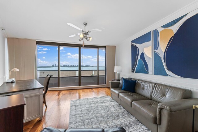 living room featuring hardwood / wood-style flooring, crown molding, and ceiling fan