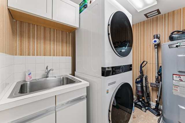 100 Lakeshore Dr Unit 457, North Palm Beach, FL 33408 - laundry area with cabinet space, stacked washing machine and dryer, and electric water heater