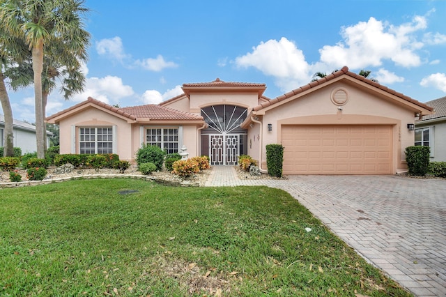 mediterranean / spanish home with a front yard and a garage