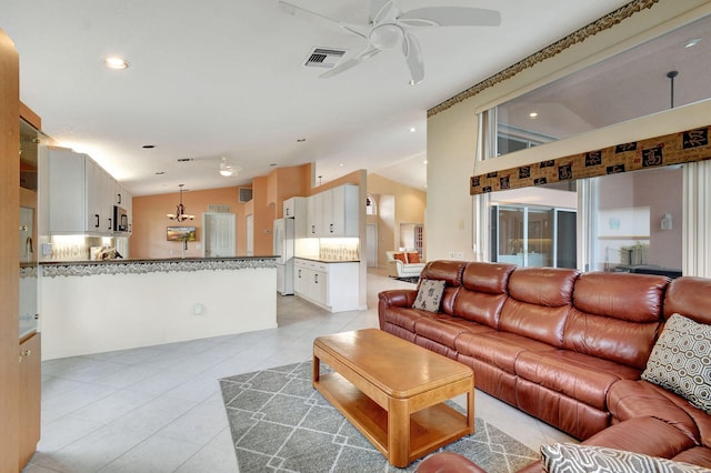 tiled living room with ceiling fan and vaulted ceiling