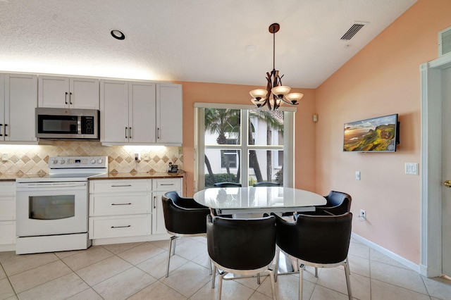 kitchen featuring pendant lighting, white cabinetry, lofted ceiling, and white range with electric cooktop