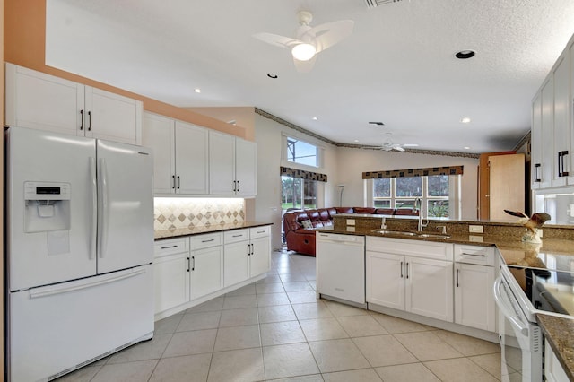 kitchen featuring white appliances, tasteful backsplash, sink, white cabinets, and light tile patterned floors