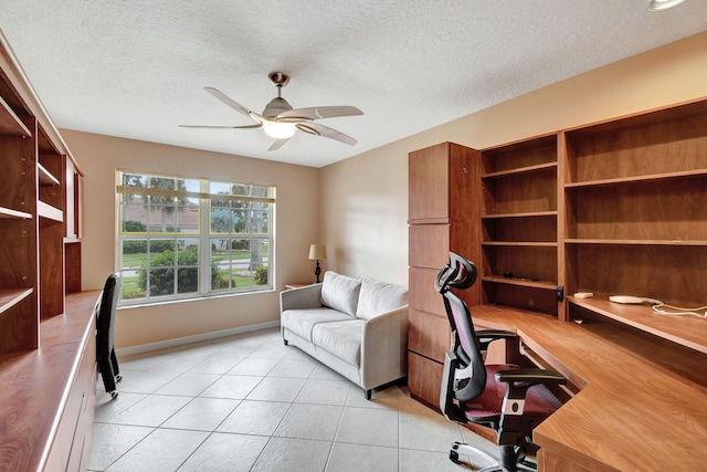 tiled office space featuring a textured ceiling and ceiling fan