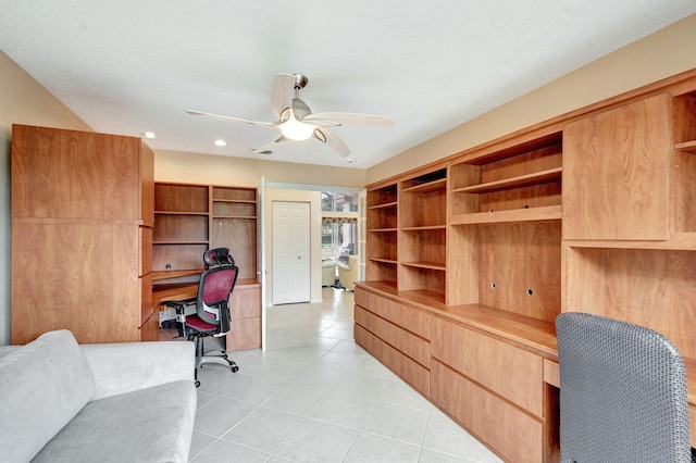 tiled home office featuring built in desk, a textured ceiling, and ceiling fan