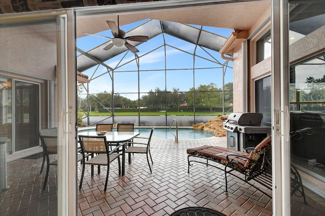 view of patio featuring ceiling fan, a lanai, and a grill