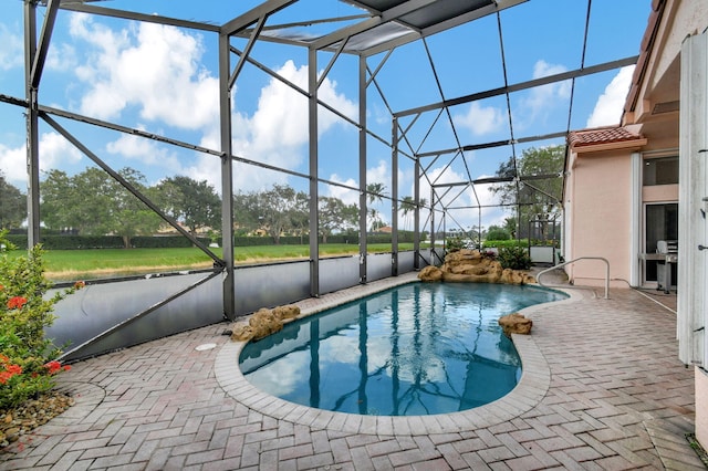 view of pool with a patio and glass enclosure