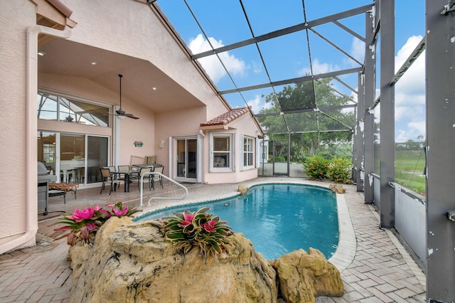 view of swimming pool featuring a patio, a lanai, and ceiling fan