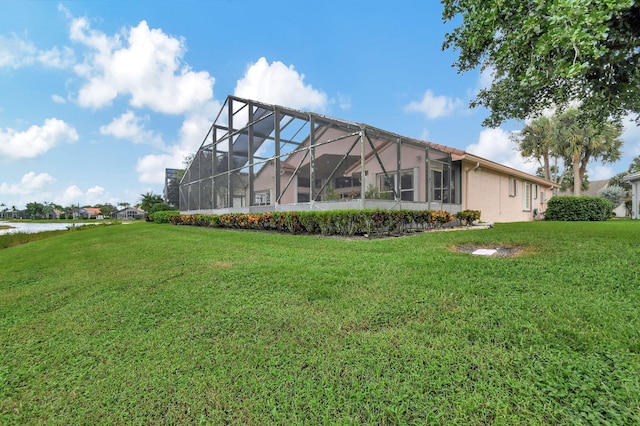 exterior space featuring a yard, a water view, and a lanai