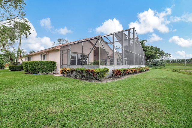 view of home's exterior featuring a yard and glass enclosure