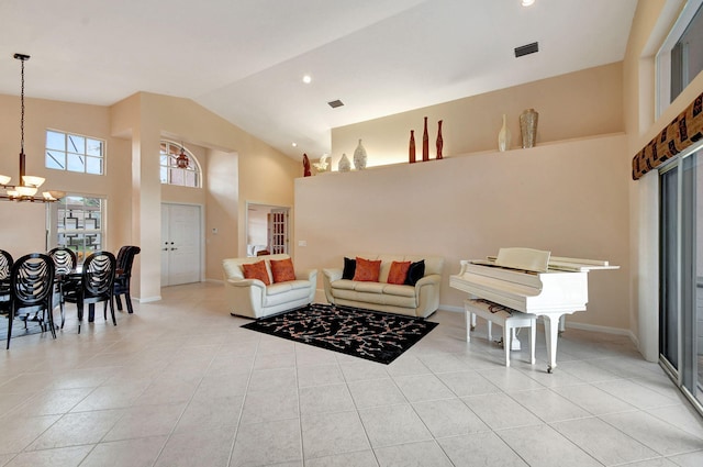 living room with light tile patterned flooring, a notable chandelier, and high vaulted ceiling