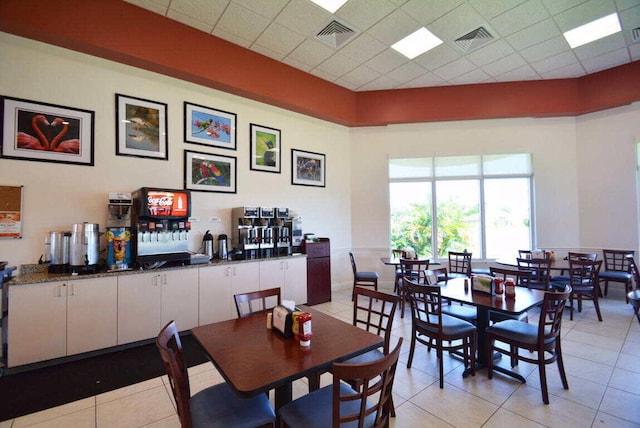 tiled dining area with a paneled ceiling