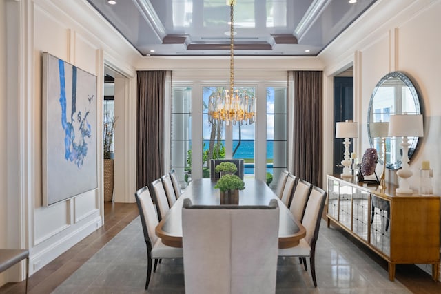 dining area with crown molding, a tray ceiling, and an inviting chandelier