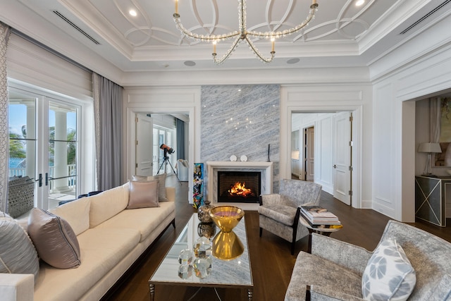 living room featuring ornamental molding, dark wood-type flooring, a notable chandelier, and french doors