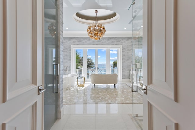 tiled entryway featuring a tray ceiling, an inviting chandelier, crown molding, and french doors