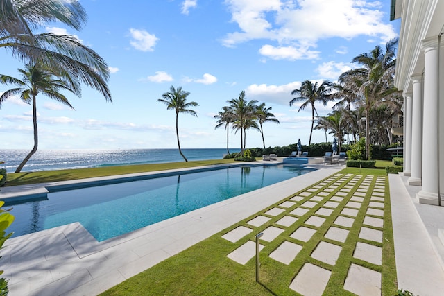 view of pool with a water view and a patio area