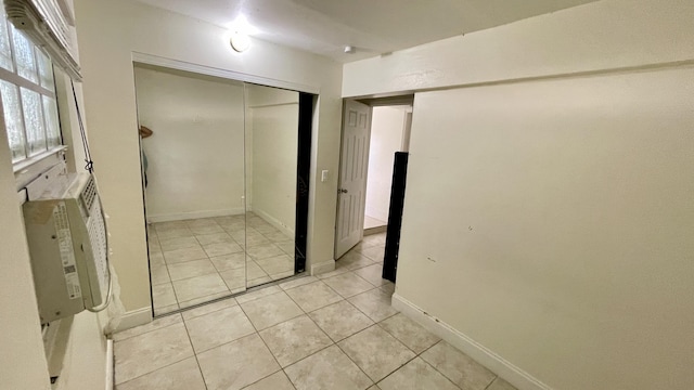 interior space featuring a closet, baseboards, and light tile patterned flooring