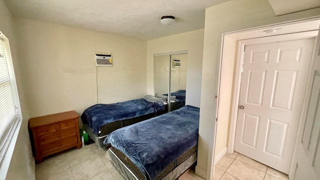 tiled bedroom featuring a closet and a wall mounted AC