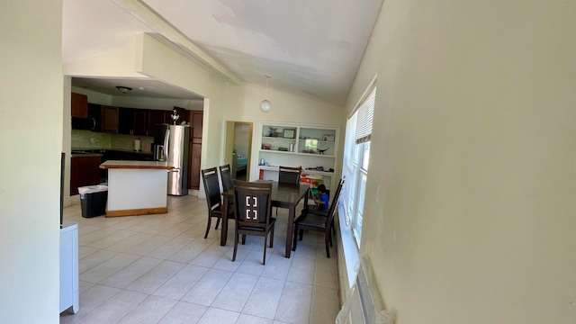 tiled dining room with vaulted ceiling