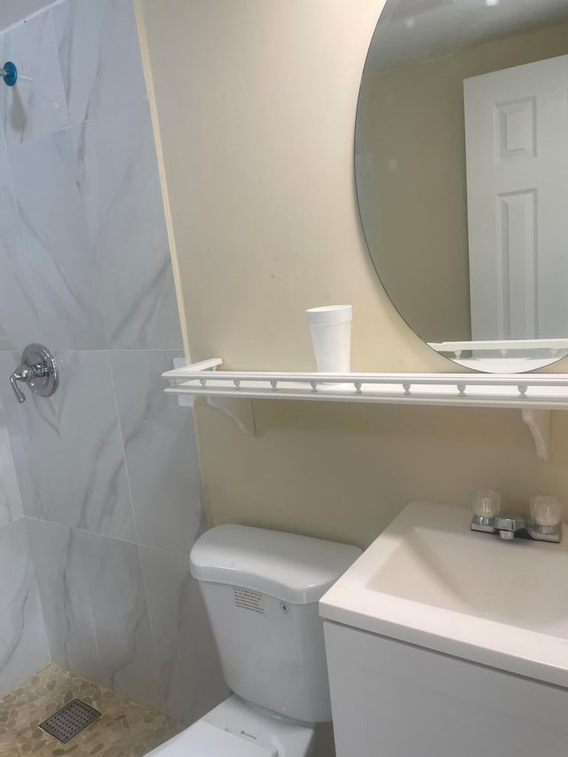 bathroom with vanity, toilet, tile walls, and a shower