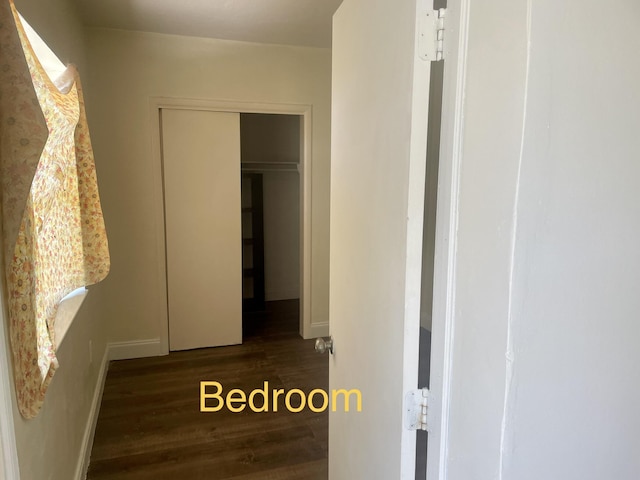hallway featuring wood finished floors and baseboards