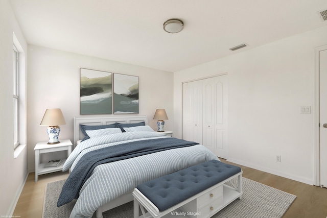 bedroom with light hardwood / wood-style flooring, a closet, and multiple windows