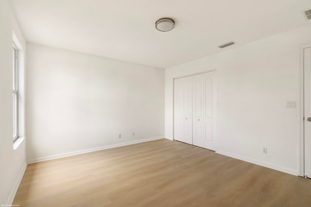 unfurnished bedroom featuring light hardwood / wood-style flooring and a closet