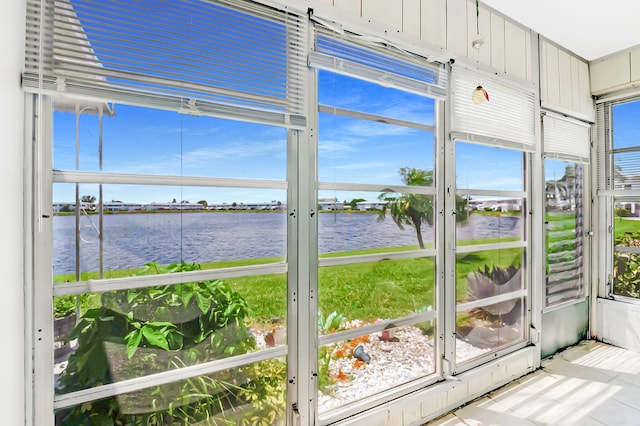 unfurnished sunroom featuring a water view