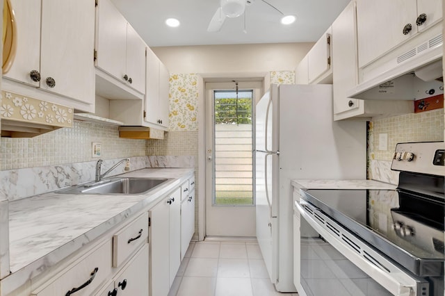 kitchen with a sink, stainless steel electric range, under cabinet range hood, and light countertops