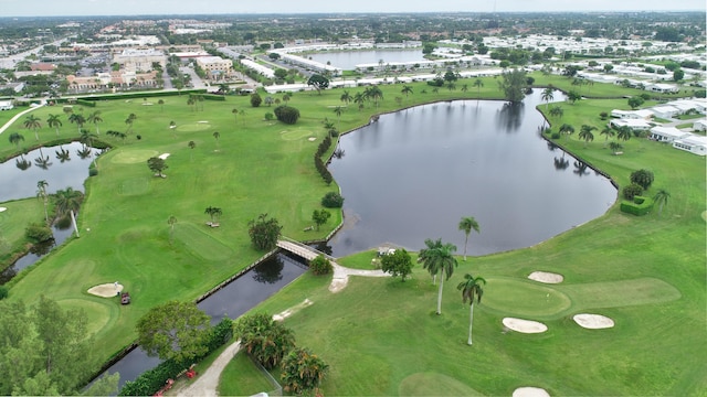 birds eye view of property with view of golf course and a water view