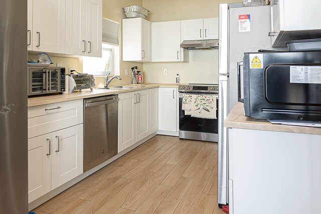 kitchen featuring white cabinetry, light hardwood / wood-style floors, appliances with stainless steel finishes, and sink